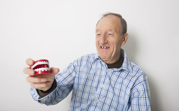 Happy man holding dentures