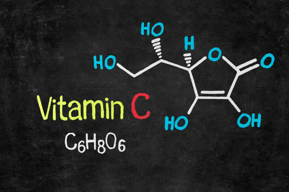 Handwritten chalk chemical formula of Vitamin C on school blackboard.